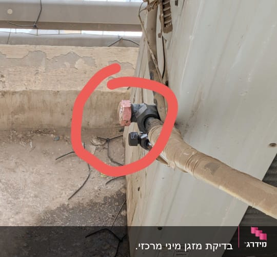 יחידת מזגן עם צינור מסומן בעיגול אדום